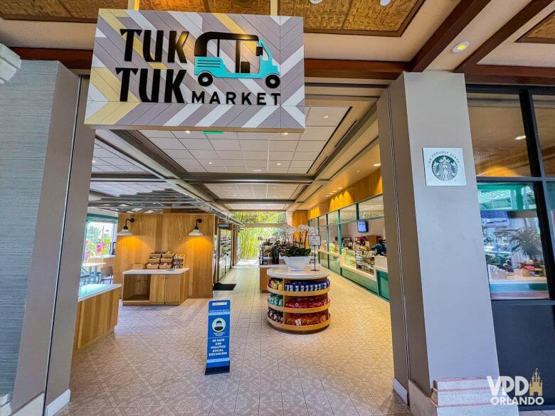 Placa do Tuk Tuk Market, com o mercadinho ao fundo. 