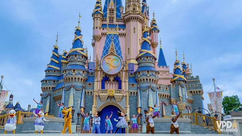 Foto do palco em frente ao castelo com vários personagens dançando.