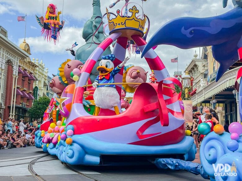 Foto de um dos carros da Festival of Fantasy no Magic Kingdom. Ele tem detalhes rosas e azuis e o Donald está na frente.