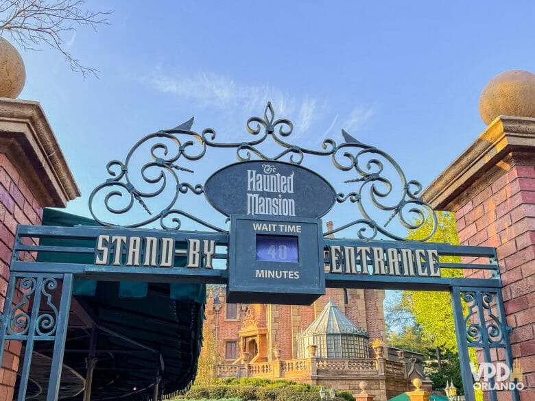 Foto da entrada da Haunted Mansion. Dá pra ver a mansão ao fundo e a entrada de Stand By marca o tempo de 40 minutos.