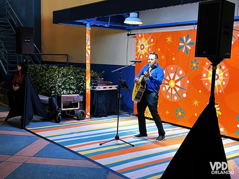 foto de um artista tocando violão em uma área com temática de natal.