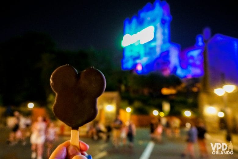 foto do sorvete do mickey com a tower of terror iluminada em azul desfocada ao fundo. os snacks fazem parte do ingresso do after hours.