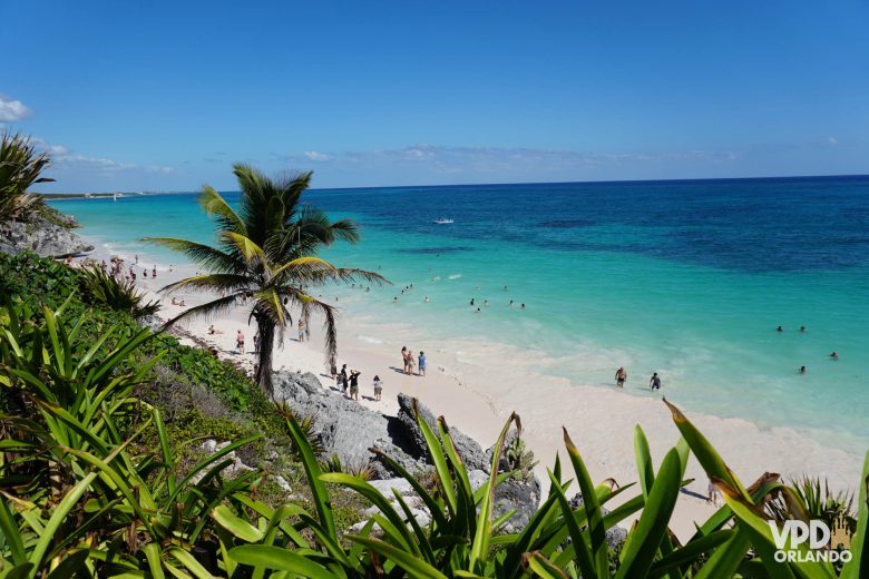 praia no México com mar azul e pessoas nadando no mar