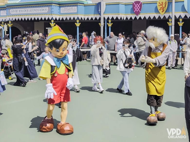 Personagens Pinóquio e Geppetto andando pelo Tokyo Disneyland