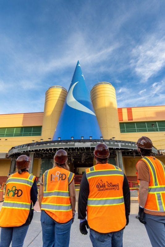 Imagem dos Imagineers observando o chapéu do Mickey Feiticeiro no Hollywood Studios